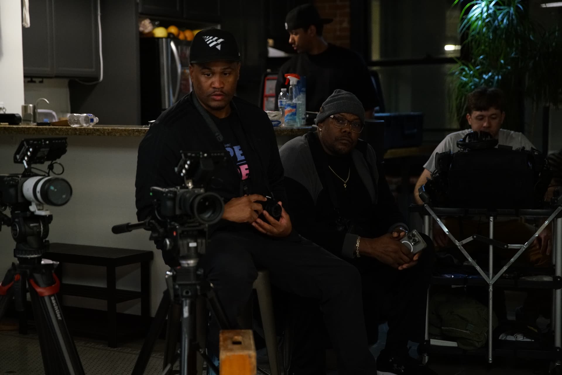 E'Ian West on set behind the cameras during production, reviewing a shot with the crew