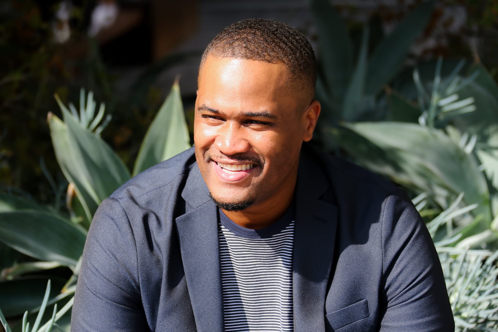 E'Ian West, producer and director, smiling in an outdoor editorial portrait in Los Angeles