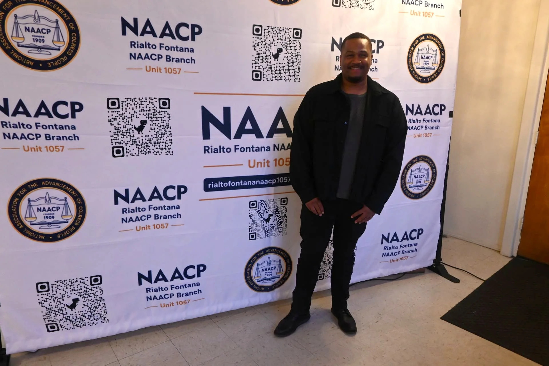 E'Ian West in front of the NAACP backdrop at the Rialto Fontana Branch event