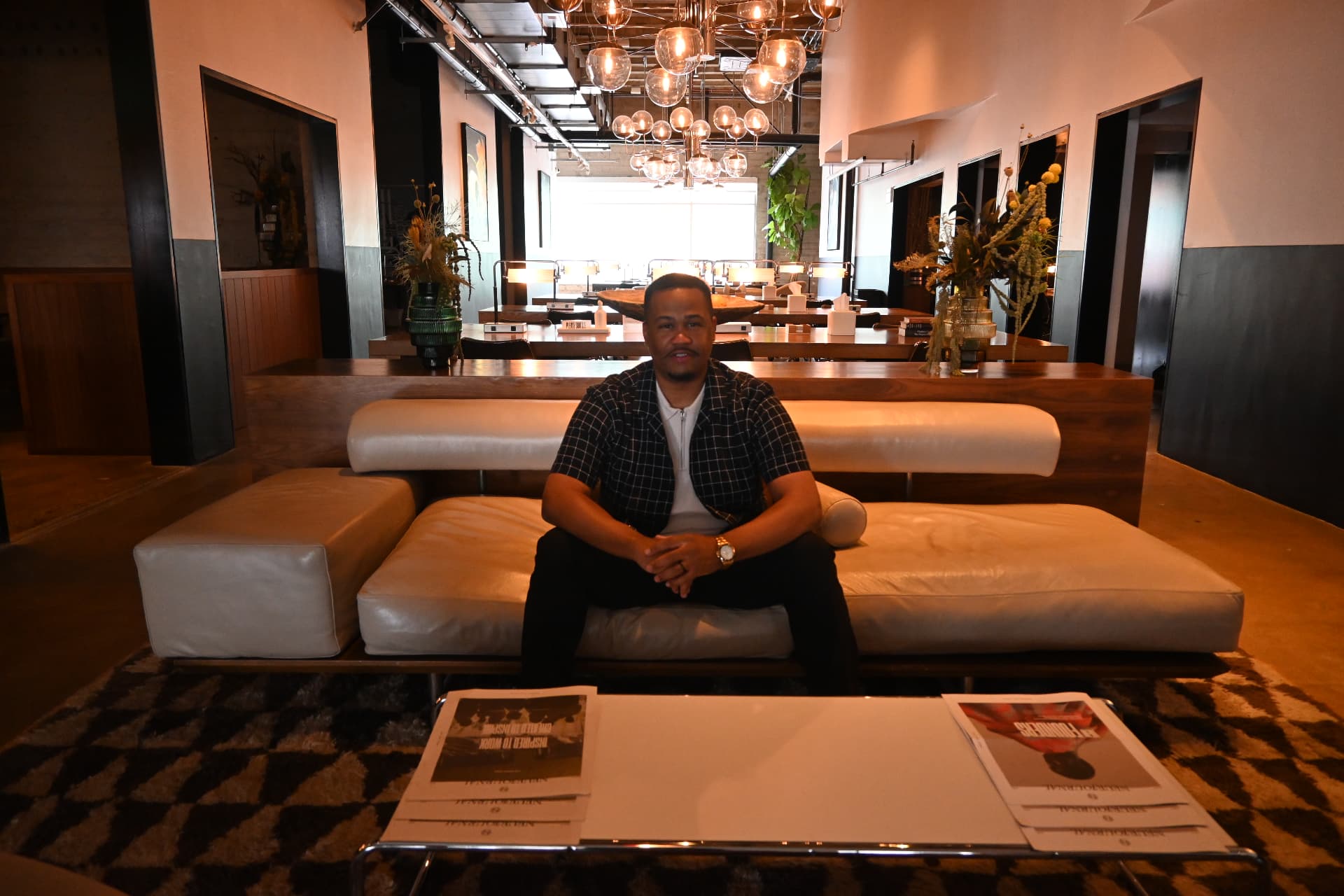 E'Ian West seated in a creative studio lounge during a production meeting